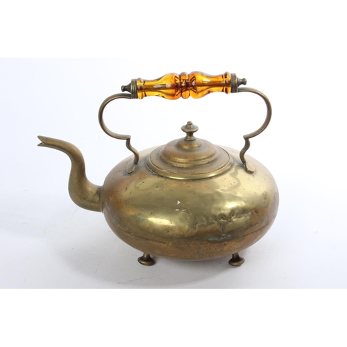 182 - An antique brass kettle with amber glass handle.