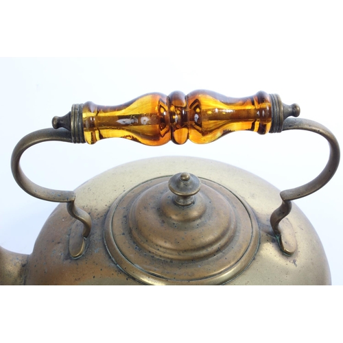 182 - An antique brass kettle with amber glass handle.