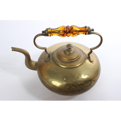 182 - An antique brass kettle with amber glass handle.