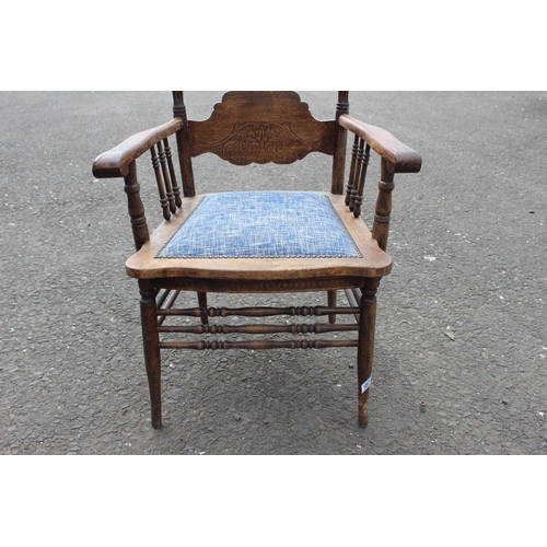 187 - An antique carved oak armchair with upholstered seat.