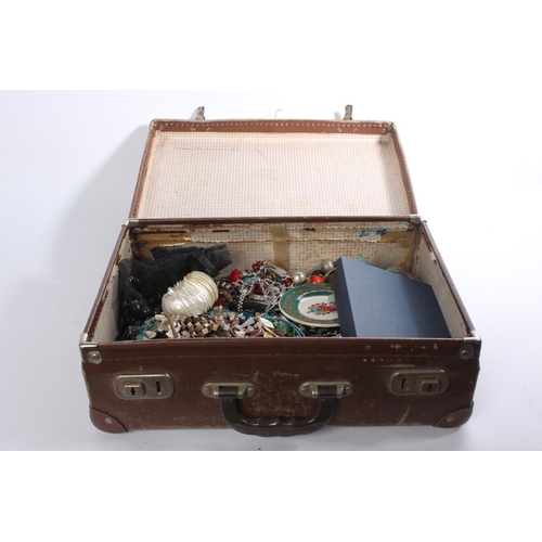 261 - A small vintage leather suitcase and a lot of assorted costume jewellery and more.