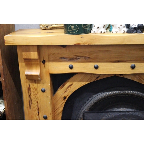 416 - A chunky pine fireplace surround with cast iron inset and fireguard.