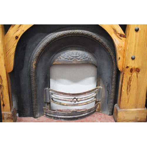 416 - A chunky pine fireplace surround with cast iron inset and fireguard.