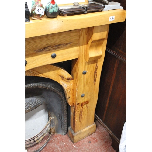 416 - A chunky pine fireplace surround with cast iron inset and fireguard.