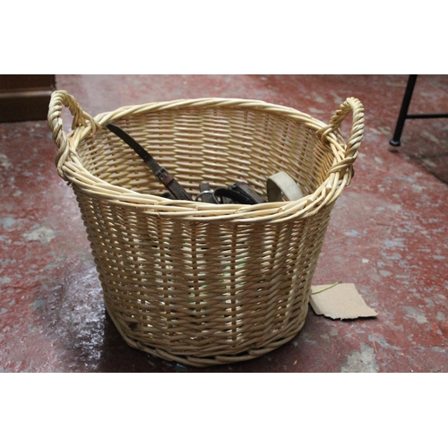 492 - A wicker basket containing a lot horse bridle gear.