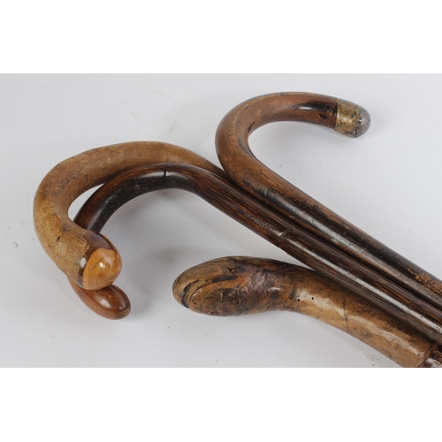 535 - A vintage snake head walking stick and three others.