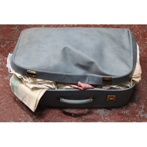 553 - A vintage luggage case containing a large lot of assorted vintage linen.