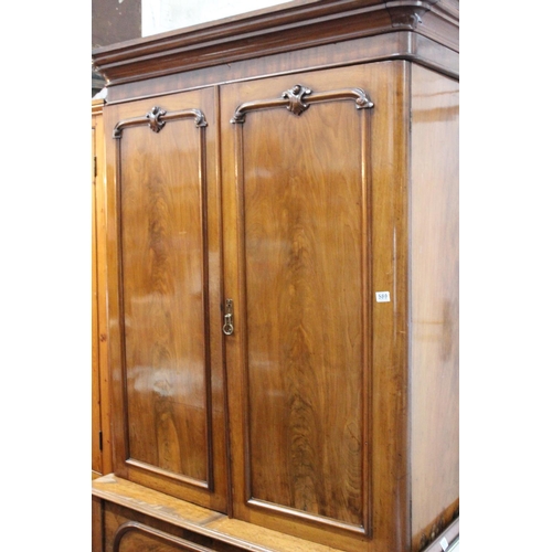 589 - An antique/Victorian mahogany two door wardrobe with decorative carving to doors on drawer base. Ret... 