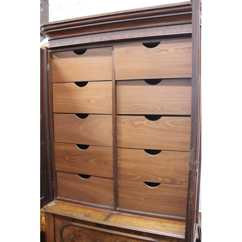 589 - An antique/Victorian mahogany two door wardrobe with decorative carving to doors on drawer base. Ret... 