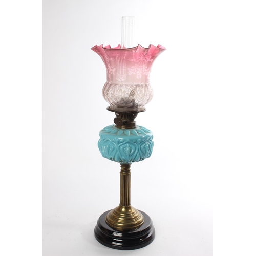 629 - A stunning Antique oil lamp with blue glass font and a stunning ruby glass shade.