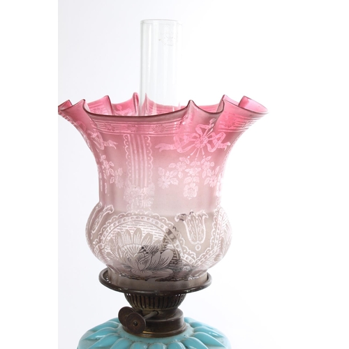 629 - A stunning Antique oil lamp with blue glass font and a stunning ruby glass shade.