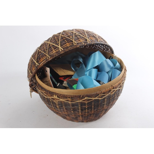 636 - A vintage rattan sewing basket and its contents.