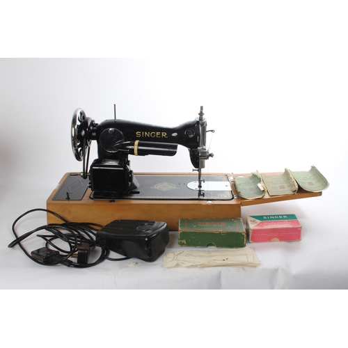 648 - A vintage cased electric Singer sewing machine, instructions and more.