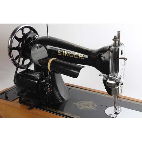 648 - A vintage cased electric Singer sewing machine, instructions and more.