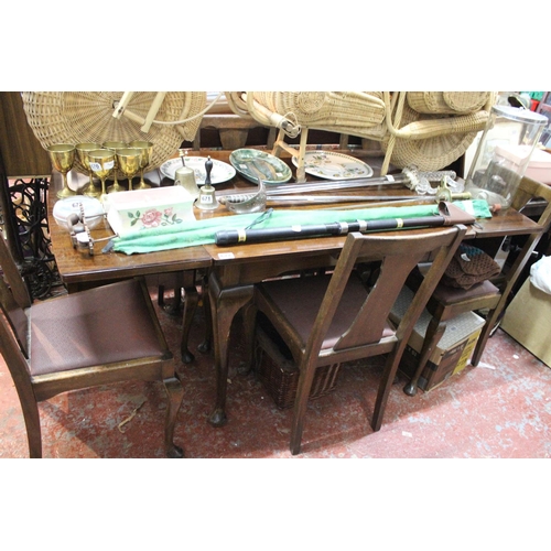 677 - A vintage mahogany drop leaf dining room table and a set of four leather upholstered chairs.