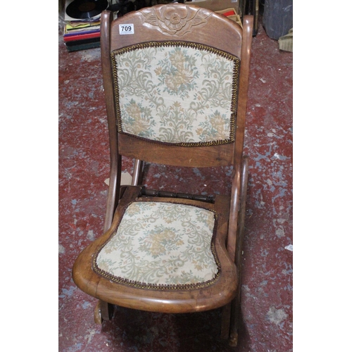 709 - A mahogany upholstered folding chair.