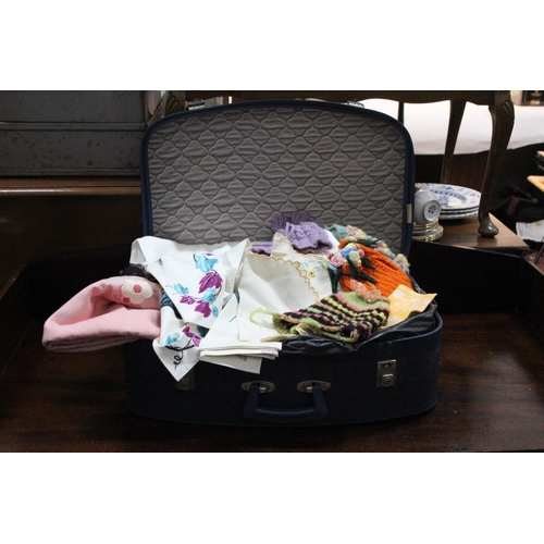 722 - A vintage Antler Foxcroft luggage case containing a lot of knitted tea cosies, Irish linen and more.