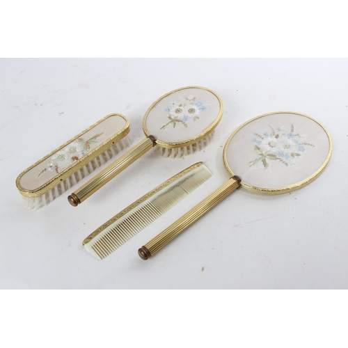 727 - A vintage four piece dressing table set with hand embroidery.