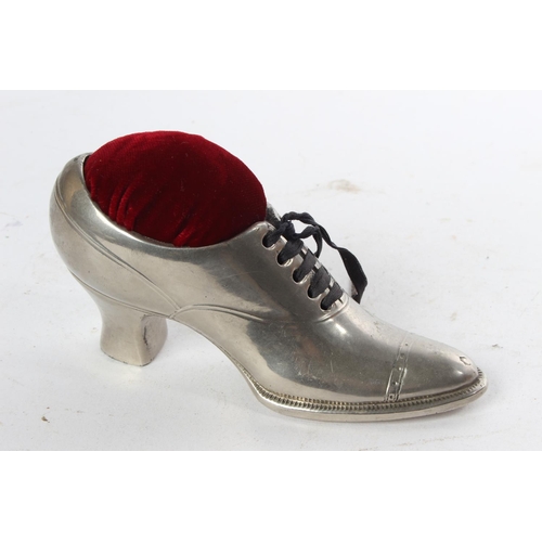 775 - A large metal shoe in the style of a pin cushion.