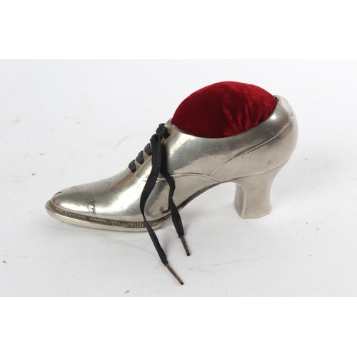 775 - A large metal shoe in the style of a pin cushion.