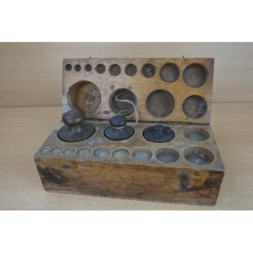 810 - A wood cased set of brass weights.