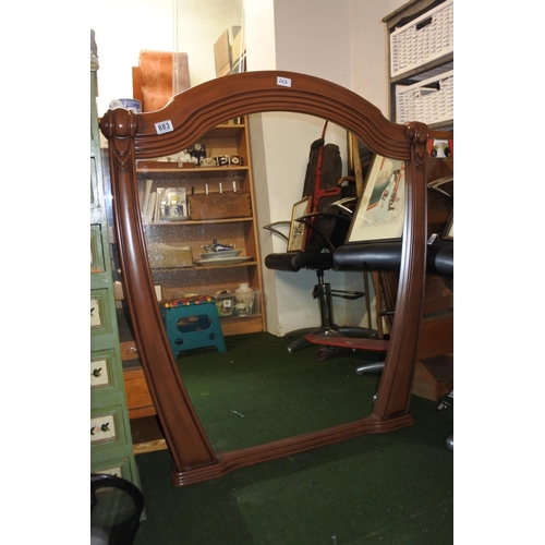 883 - A large decorative mirror in wood effect frame. Approx 106x92cm.