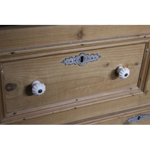 936 - A stunning antique pine chest of four drawers with porcelain drawer pulls.