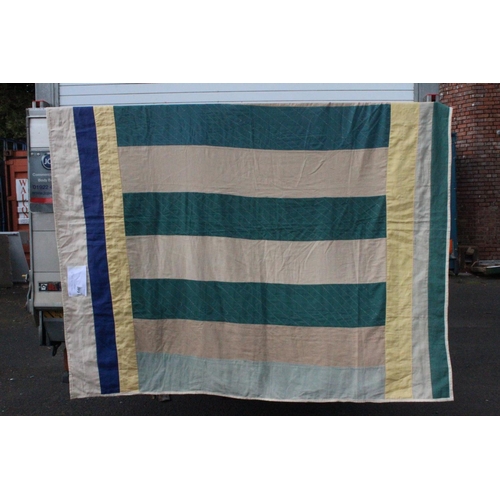 946 - An Irish linen green, yellow and beige patchwork quilt. Measuring 66x73inches.