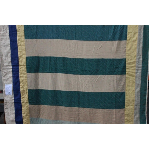 946 - An Irish linen green, yellow and beige patchwork quilt. Measuring 66x73inches.