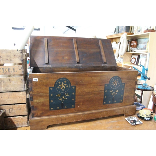 218 - A wooden blanket chest with decorative detail.