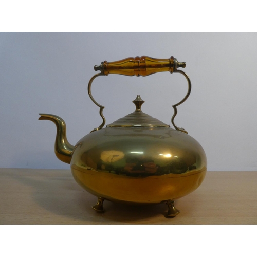 66 - A vintage brass kettle with amber glass handle.