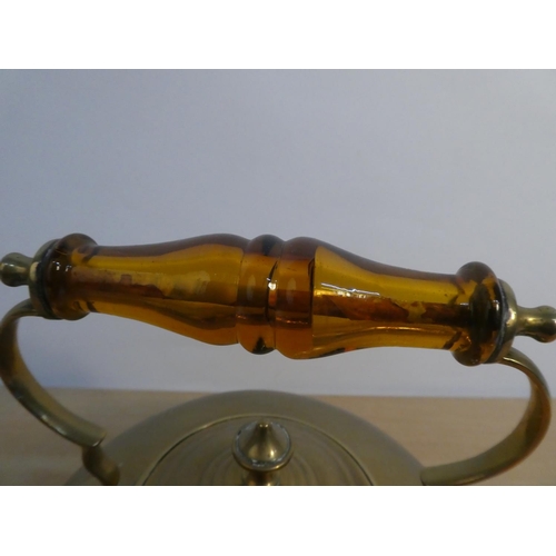 66 - A vintage brass kettle with amber glass handle.