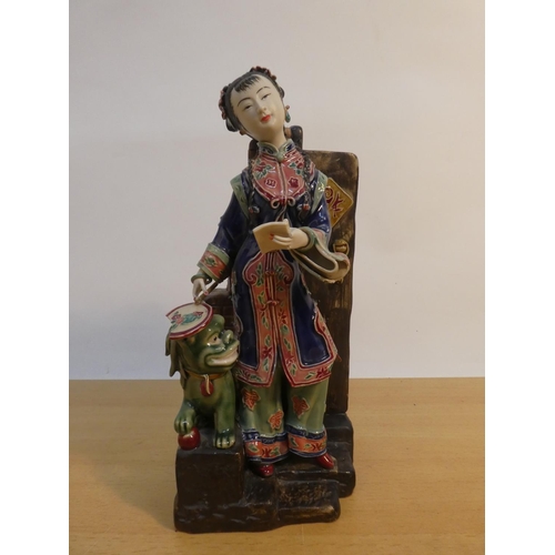 83 - An Oriental ceramic figure with foo dog, signed to base (a/f).