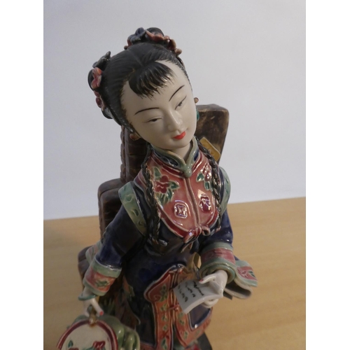 83 - An Oriental ceramic figure with foo dog, signed to base (a/f).