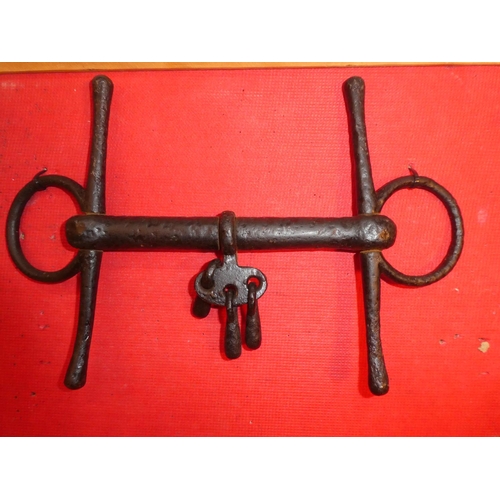 641 - An antique wrought iron horse bit and a leather strap.