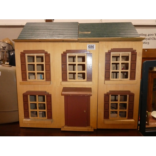 686 - A wooden dolls house containing furniture, dolls and more.