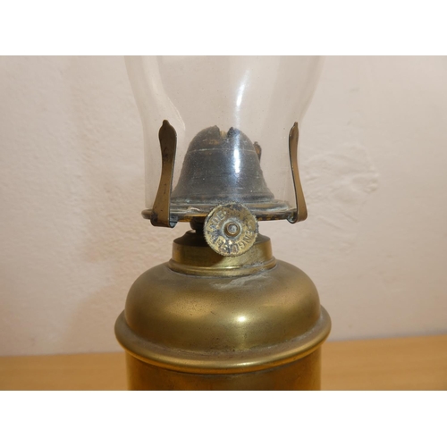 679 - An antique oil lamp with heavy brass base.