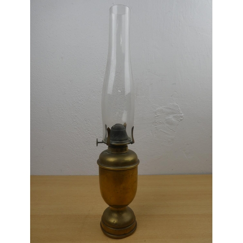 679 - An antique oil lamp with heavy brass base.