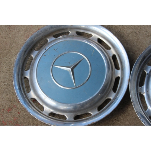 68 - Two vintage Mercedes hubcaps.