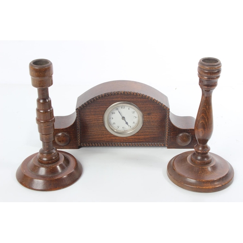 159 - A vintage oak mantle clock and a pair of oak turned candlesticks.