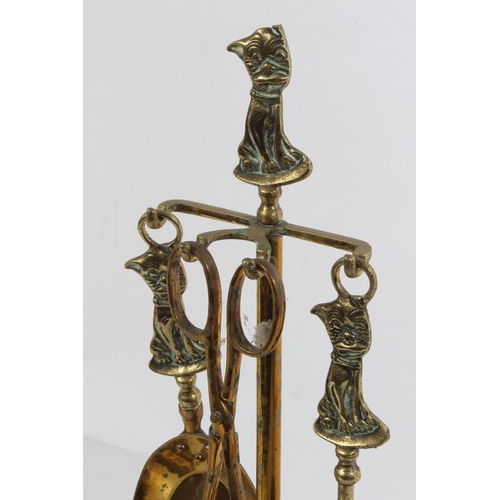 198 - A vintage brass companion set with cat design.