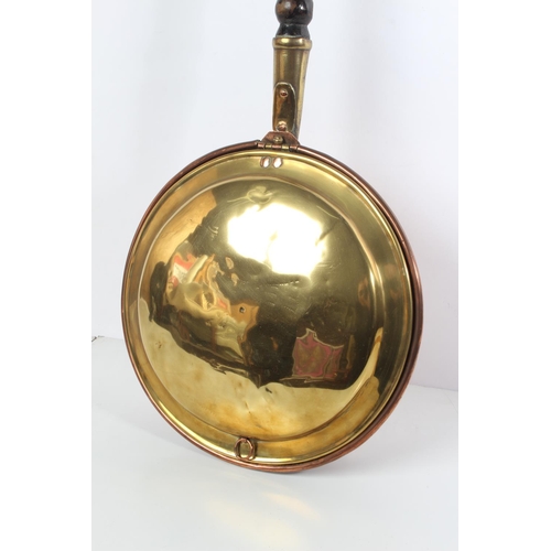 69 - An antique brass and copper bed warmer.