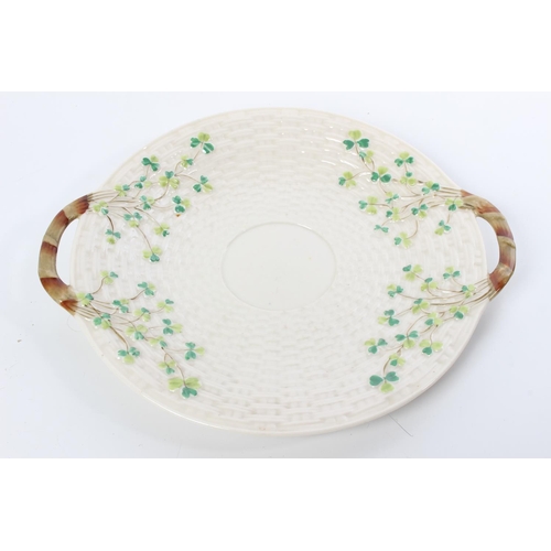 92 - A Belleek First Period twin handled plate, hand painted with shamrock detail.