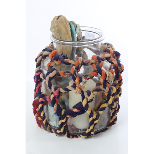 149 - A vintage glass container with fabric rope cover.