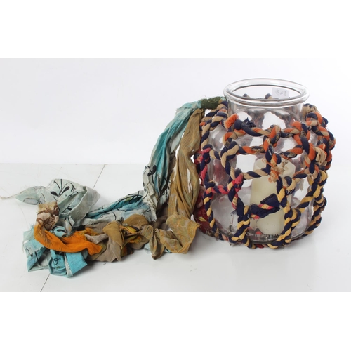 149 - A vintage glass container with fabric rope cover.