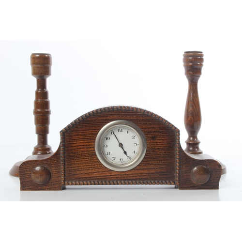 159 - A vintage oak mantle clock and a pair of oak turned candlesticks.