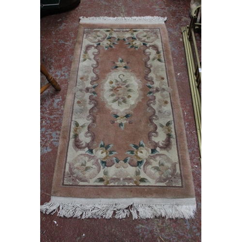 177 - A pink floral patterned floor rug.