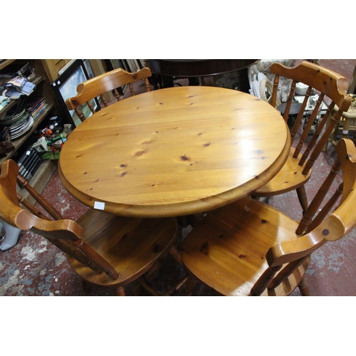 390 - A circular pine kitchen table and four chair set.