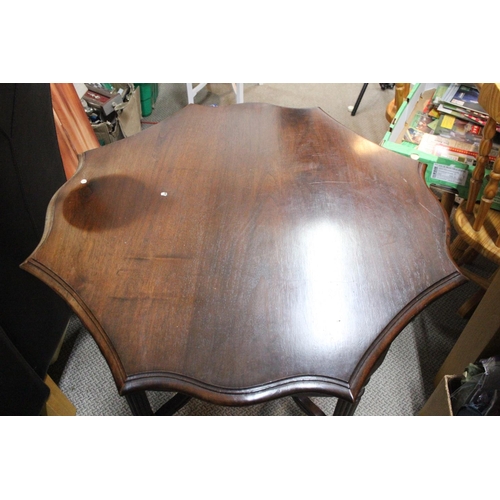 385 - An antique mahogany table with undershelf on casters.