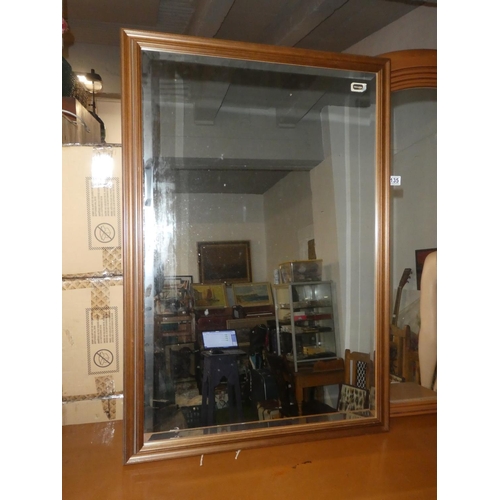 134 - A large oak framed mirror with bevelled glass.